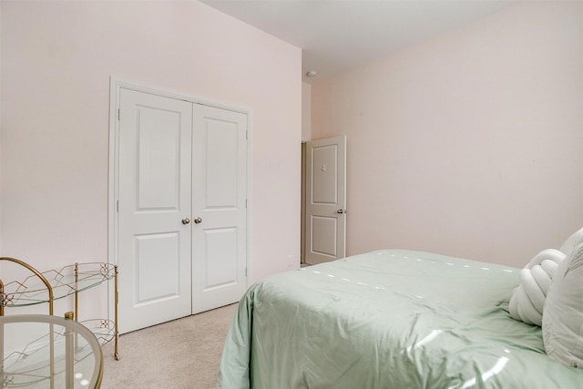 bedroom with a closet and light carpet