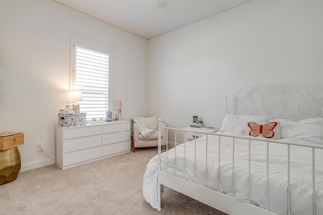 bedroom featuring baseboards, a ceiling fan, and light colored carpet