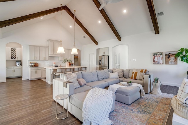 living room with beamed ceiling, dark wood-style flooring, high vaulted ceiling, and visible vents
