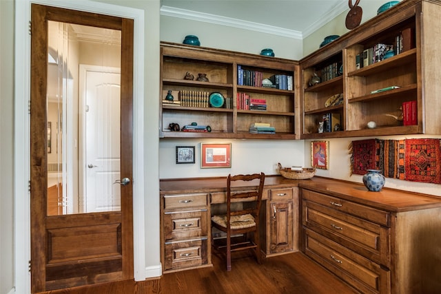 office area featuring built in study area, ornamental molding, and dark wood-type flooring