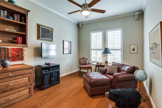 living area featuring light wood-type flooring, a ceiling fan, baseboards, and ornamental molding