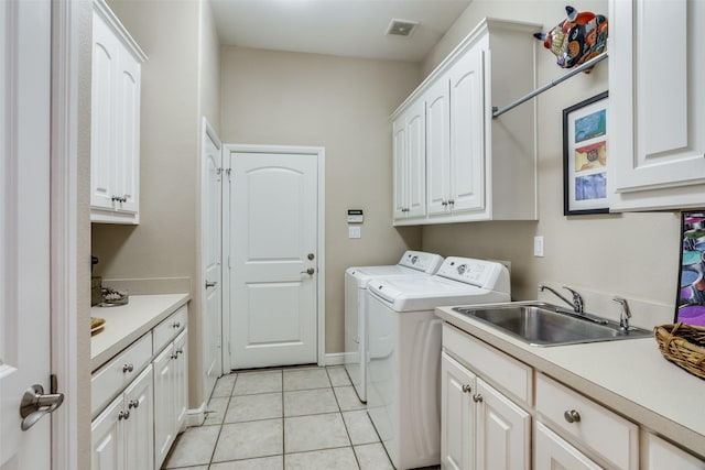 clothes washing area with visible vents, separate washer and dryer, a sink, cabinet space, and light tile patterned floors
