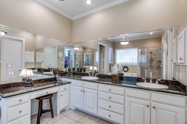 bathroom featuring a sink, tile patterned floors, crown molding, and a stall shower