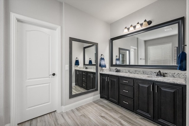 2114 Burke Dr, Princeton, TX 75407 - full bathroom featuring a sink, baseboards, double vanity, and wood finished floors