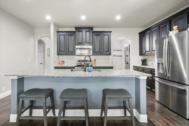 2114 Burke Dr, Princeton, TX 75407 - kitchen featuring a sink, appliances with stainless steel finishes, a kitchen bar, and arched walkways