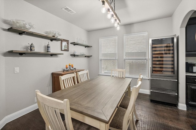2114 Burke Dr, Princeton, TX 75407 - dining space featuring visible vents, arched walkways, baseboards, and wine cooler