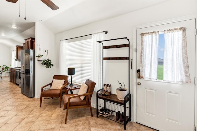 entryway featuring baseboards, ceiling fan, a wealth of natural light, and lofted ceiling