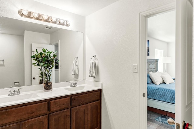 bathroom featuring visible vents, a sink, ensuite bath, and double vanity