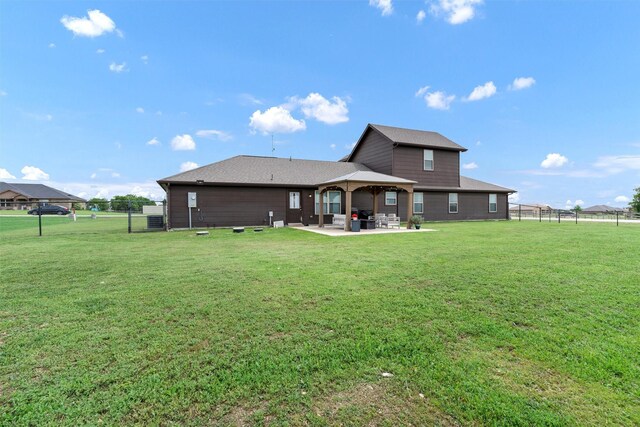 rear view of house featuring a fenced backyard, a patio, a gazebo, and a yard