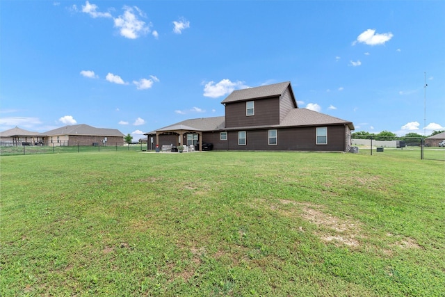 rear view of property with a fenced backyard, a shingled roof, and a yard