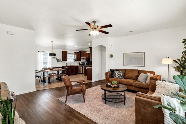 194 Hillcrest Ln, Decatur, TX 76234 - living room featuring arched walkways, a ceiling fan, dark wood-style floors, and visible vents