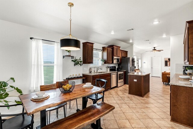 kitchen with visible vents, dark brown cabinetry, a center island, a sink, and appliances with stainless steel finishes