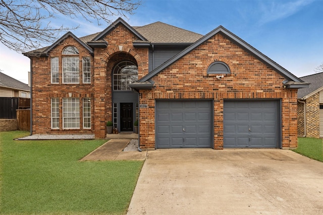 traditional-style home with roof with shingles, brick siding, a front lawn, concrete driveway, and an attached garage