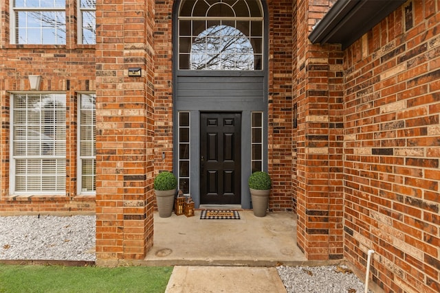view of exterior entry featuring brick siding