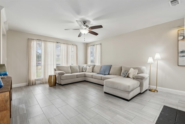 living room with a ceiling fan, baseboards, visible vents, and a wealth of natural light