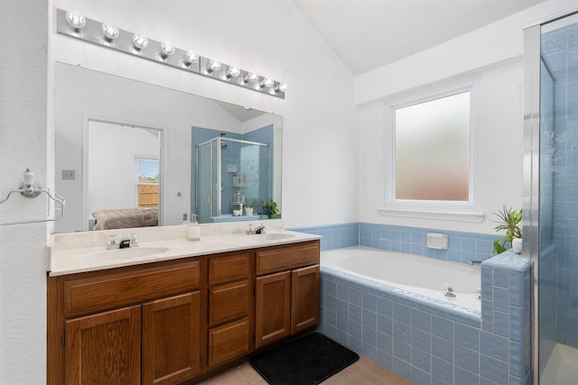 ensuite bathroom with double vanity, a stall shower, a sink, lofted ceiling, and ensuite bath