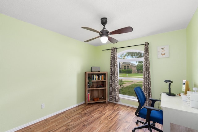 home office featuring a ceiling fan, baseboards, and wood finished floors