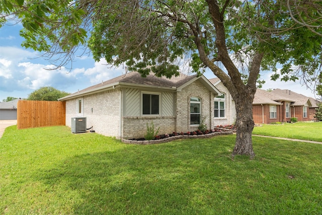 view of front of house featuring brick siding, central AC unit, a front lawn, and fence