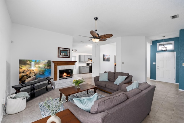 7129 Dee Cole Dr, The Colony, TX 75056 - living area featuring light tile patterned flooring, a fireplace, and a ceiling fan