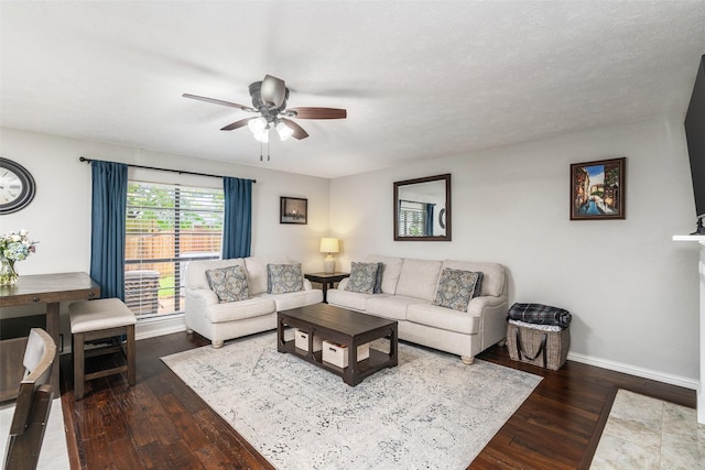 living area with baseboards, a ceiling fan, and hardwood / wood-style floors