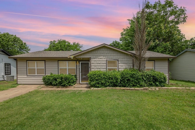 ranch-style house with roof with shingles and a front yard