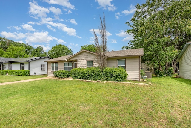 single story home featuring cooling unit and a front lawn
