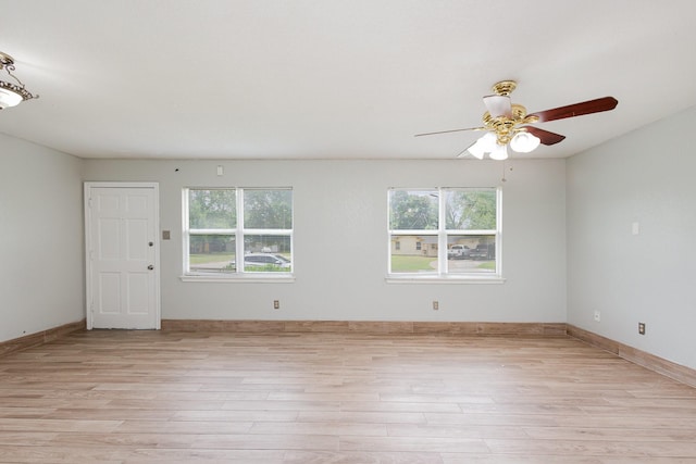 spare room featuring baseboards, a ceiling fan, and light wood finished floors