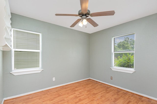 spare room with baseboards, a ceiling fan, and wood finished floors