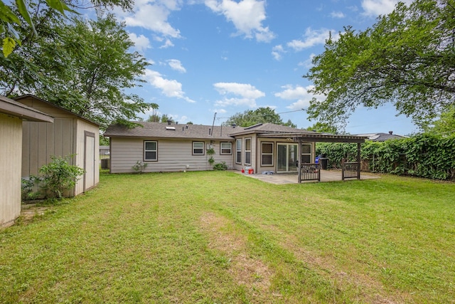 back of house with a patio, an outdoor structure, a yard, and a storage unit