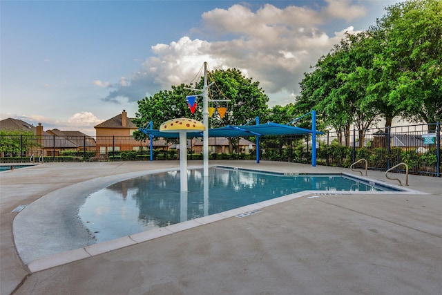 community pool featuring fence and a patio area
