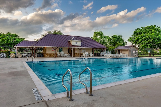pool with a patio and fence