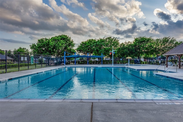 community pool with a gazebo and fence