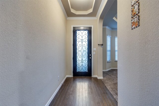 entrance foyer featuring arched walkways, a textured wall, dark wood finished floors, and a wealth of natural light