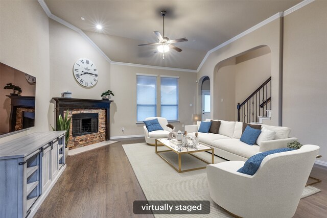living area with dark wood-style flooring, arched walkways, a fireplace with flush hearth, and ceiling fan