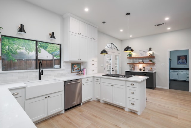 kitchen with white cabinets, a sink, stainless steel appliances, decorative backsplash, and visible vents