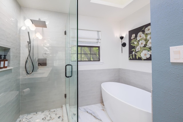 bathroom with wainscoting, tile walls, a soaking tub, and a shower stall