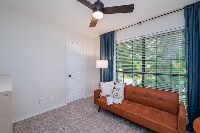 living area with baseboards, carpet, and ceiling fan