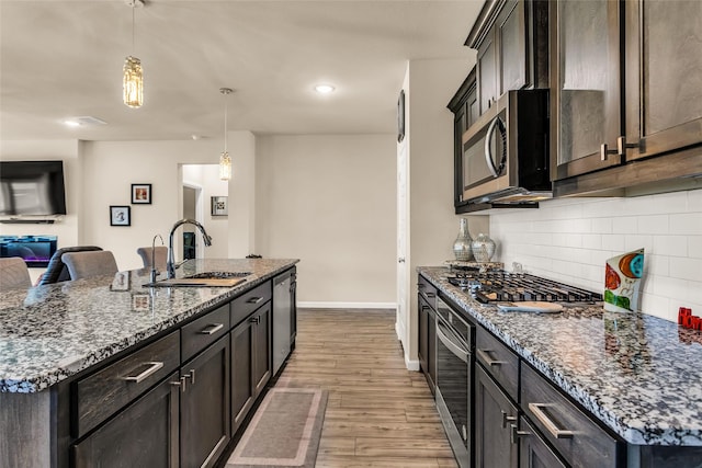 621 Hazeltine Rd, Red Oak, TX 75154 - kitchen featuring a sink, stainless steel appliances, wood finished floors, backsplash, and baseboards