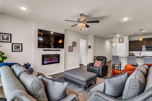 621 Hazeltine Rd, Red Oak, TX 75154 - living room with dark wood finished floors, recessed lighting, baseboards, a glass covered fireplace, and ceiling fan