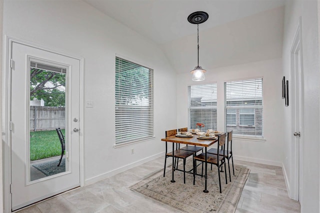 dining area with washer / clothes dryer, lofted ceiling, and baseboards
