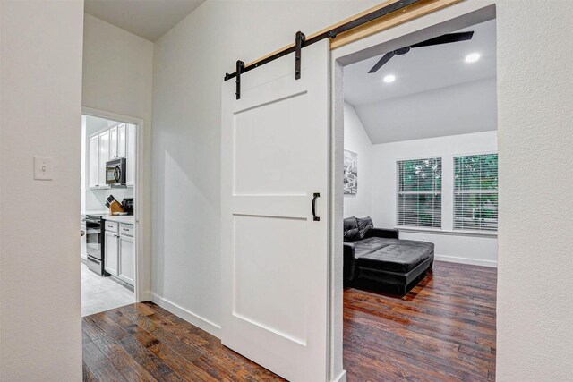 living room featuring ornate columns, baseboards, wood finished floors, and a tray ceiling