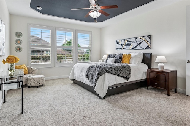 carpeted bedroom featuring baseboards and ceiling fan