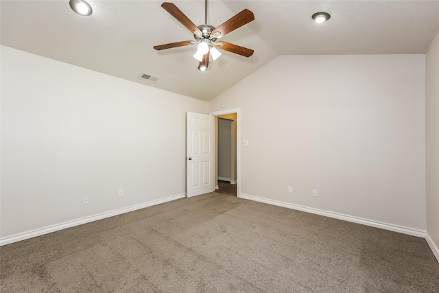 carpeted spare room with vaulted ceiling, baseboards, a ceiling fan, and visible vents
