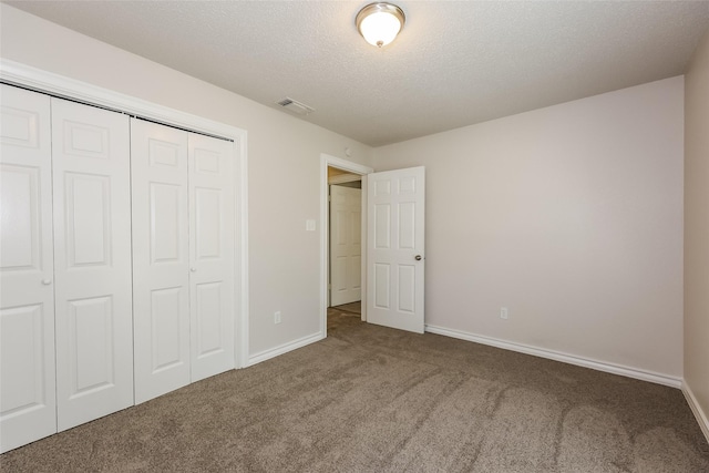 unfurnished bedroom with visible vents, carpet floors, a closet, baseboards, and a textured ceiling
