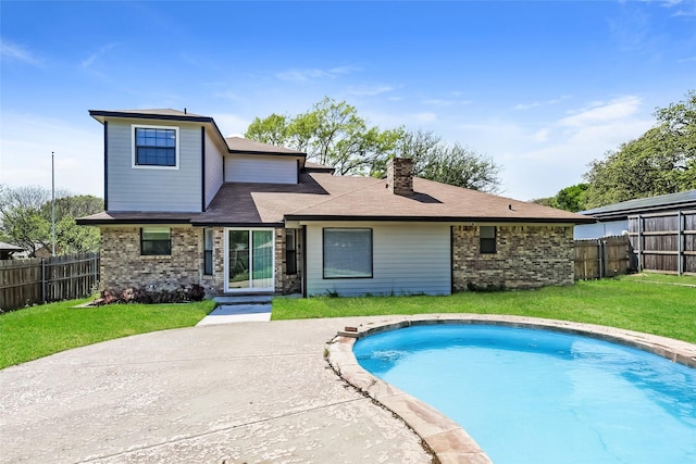 back of property featuring a yard, brick siding, a fenced in pool, and fence private yard