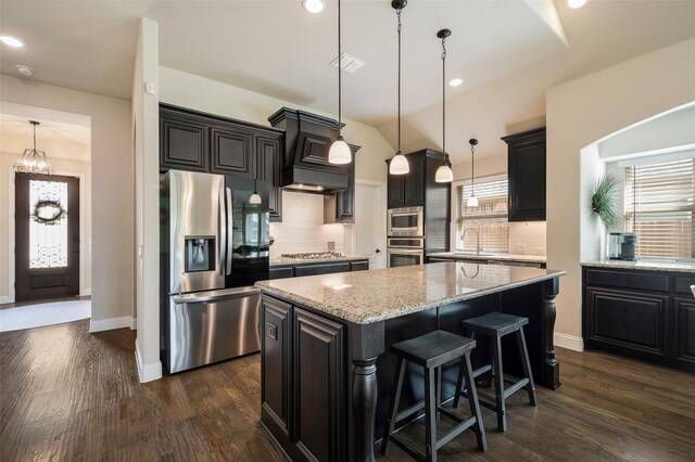 kitchen featuring decorative backsplash, a kitchen island, dark wood-style flooring, custom exhaust hood, and stainless steel appliances
