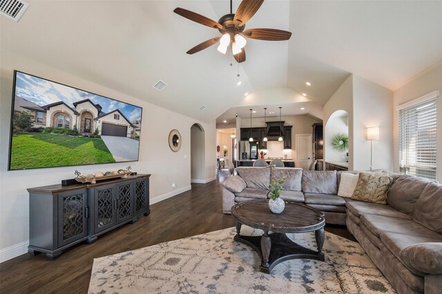living room with visible vents, a ceiling fan, lofted ceiling, arched walkways, and dark wood finished floors