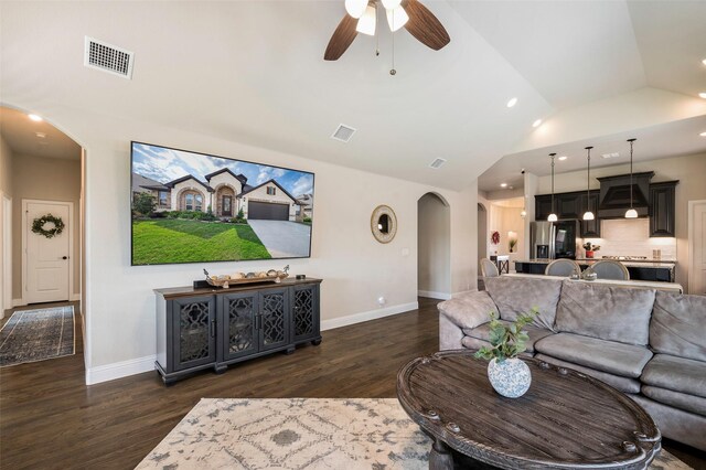 living area featuring dark wood-style flooring, arched walkways, baseboards, and visible vents