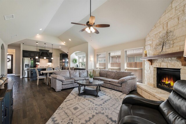 living room with a fireplace, arched walkways, lofted ceiling, and dark wood-type flooring