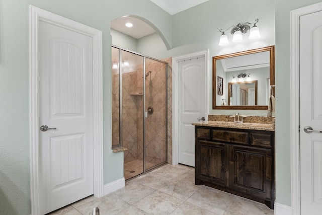 bathroom featuring crown molding, tile patterned flooring, a shower stall, vanity, and baseboards